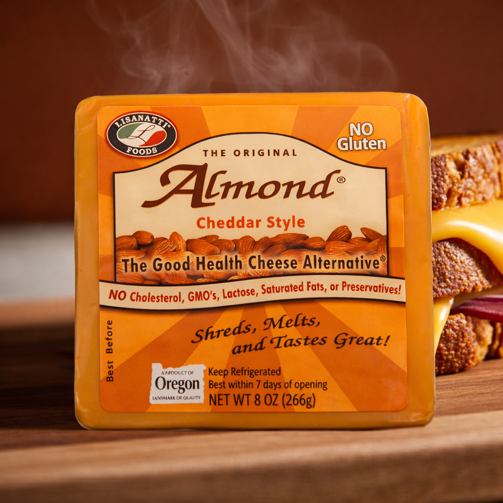 Almond cheese block with packaging on a wooden surface with melty grilled cheese sandwich in background.